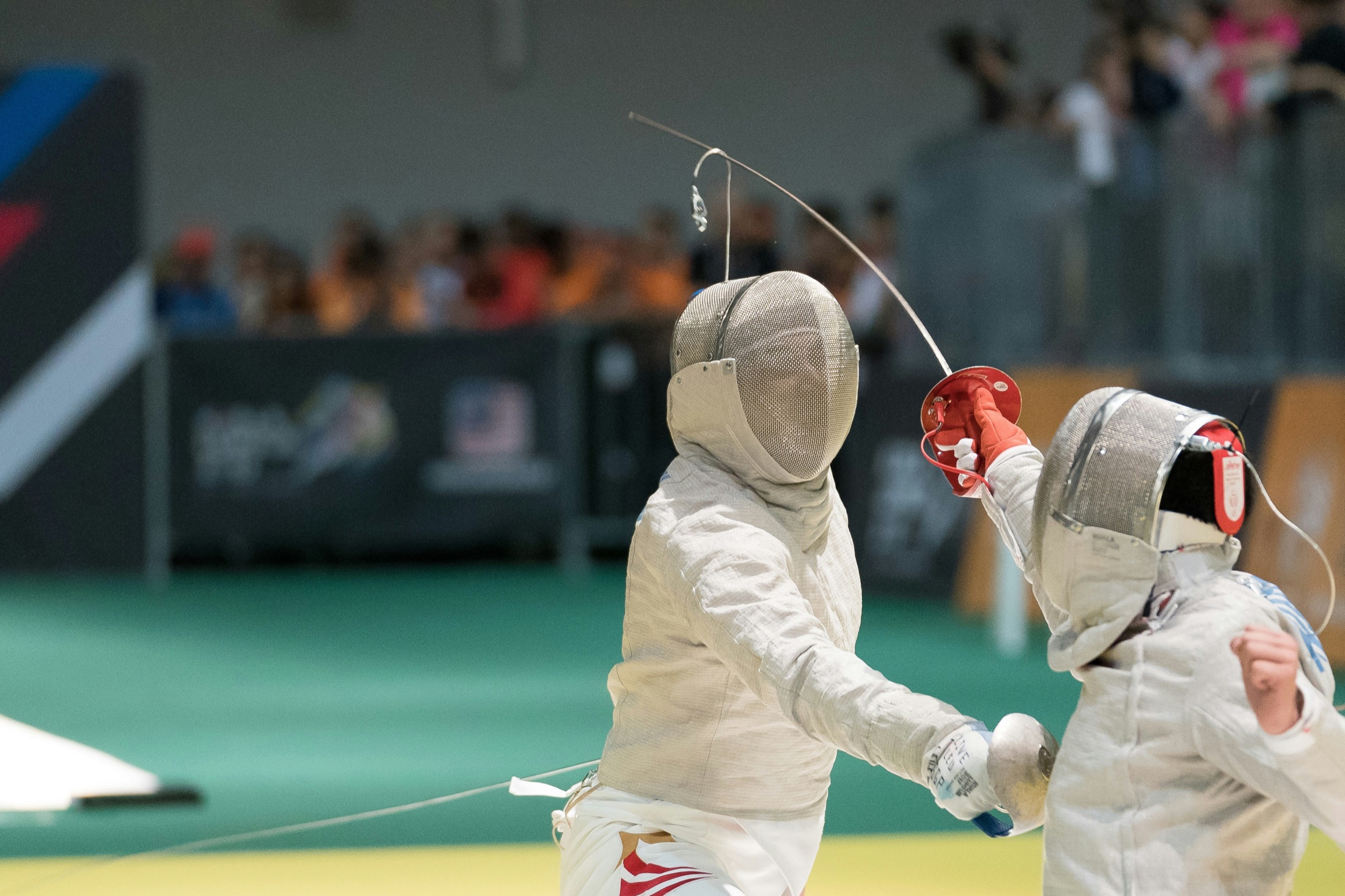 Two fencers competing with crossed blades and protective masks.
